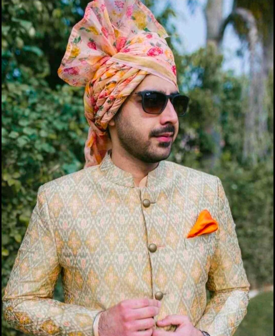 Groom in a cream sherwani wearing a hand-draped multi-colour wedding safa